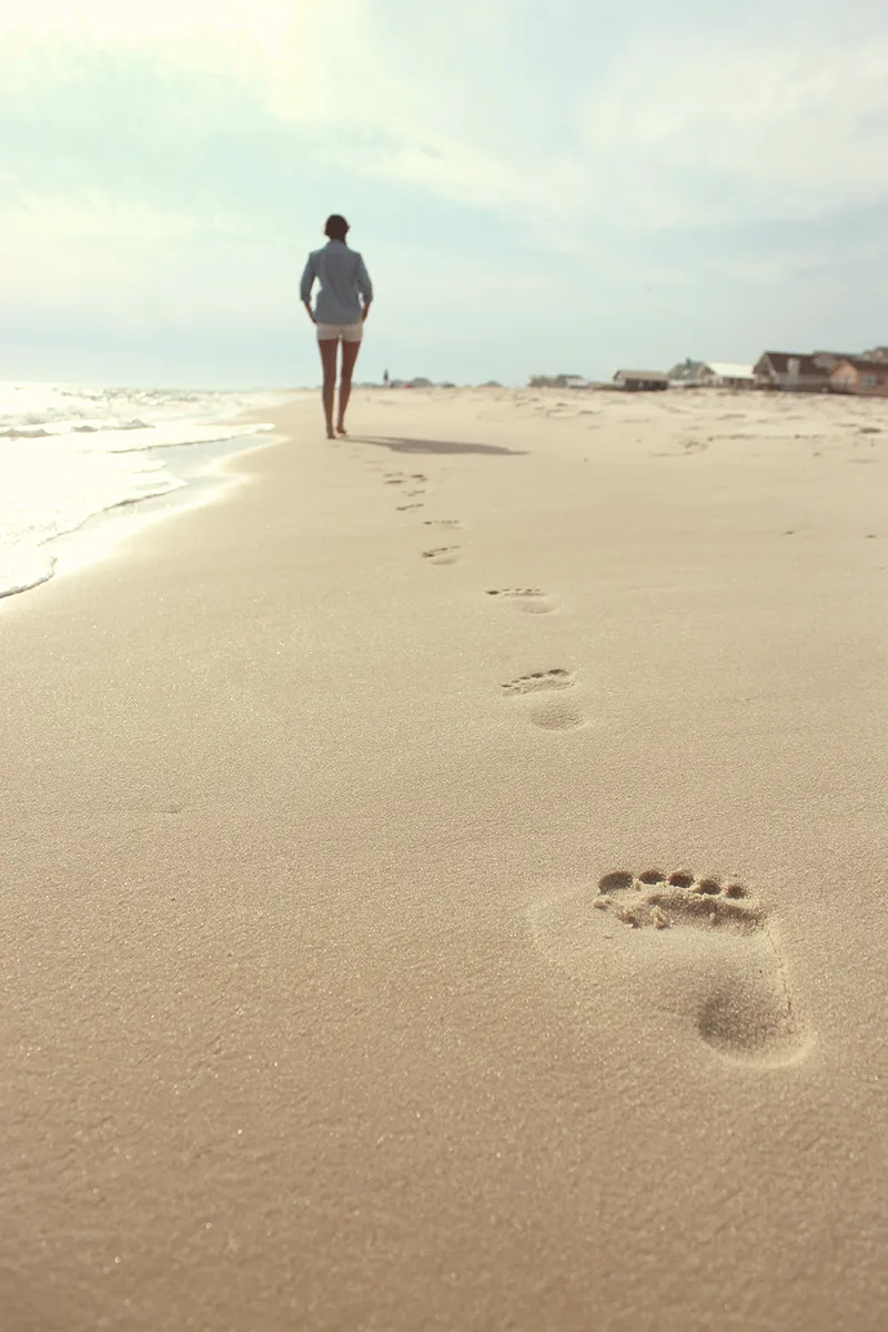Coaching - kvinna som går promenad på stranden